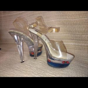 Clear plastic straps, cushiony sole. 6” stiletto heels, fish bowls in platforms.